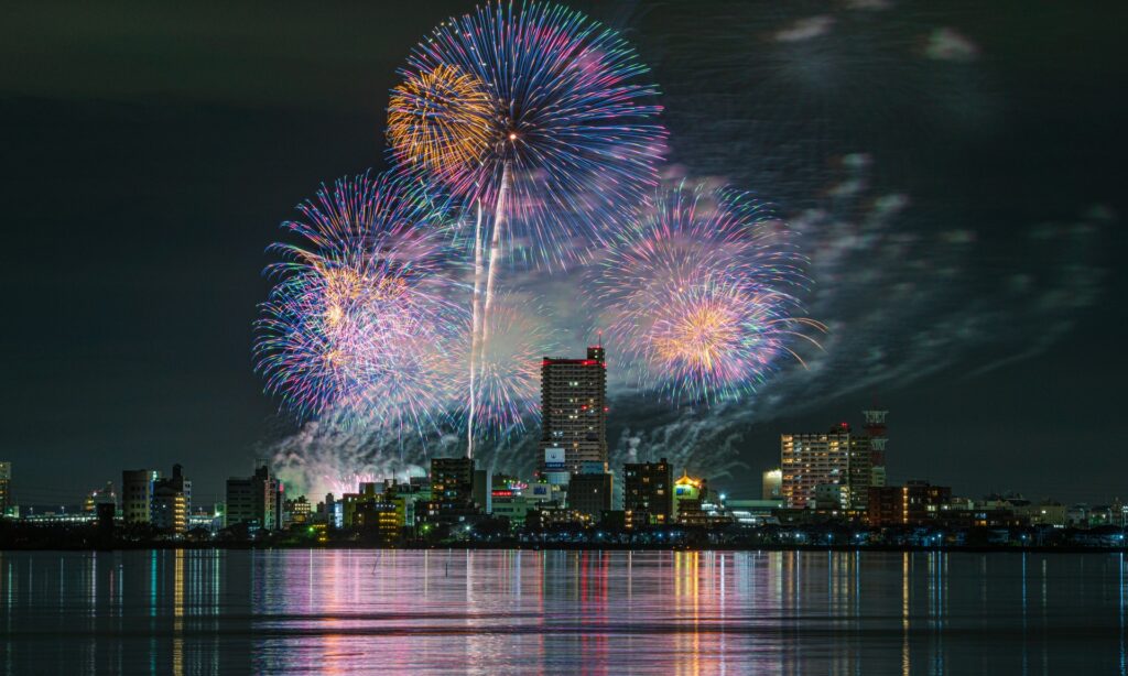 土浦全国花火競技大会で夜空と湖面を彩るカラフルな花火と市街の夜景