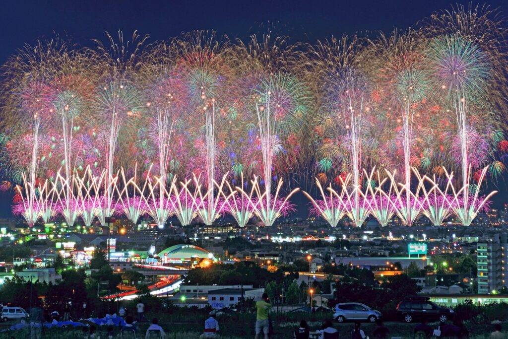 長岡まつり大花火大会で夜空を覆う色とりどりの花火と街の明かりが共演する光景